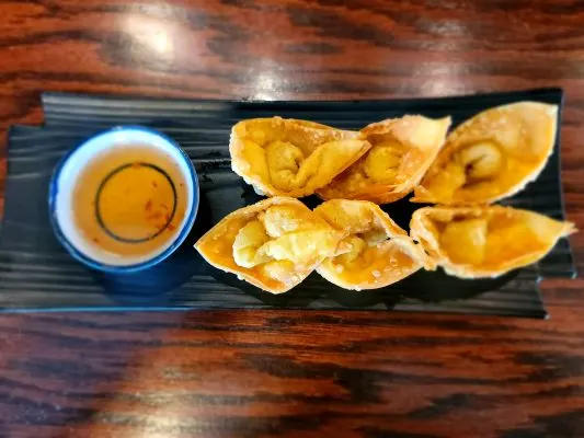 Crispy Wonton — Thin wonton wrapper filled with seasoned minced pork, folded to the "Bishop's Hat", deep-fried until golden, and served with sweet and tangy chili sauce.