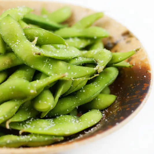 Edamame — Steamed and salted soybean pods.
