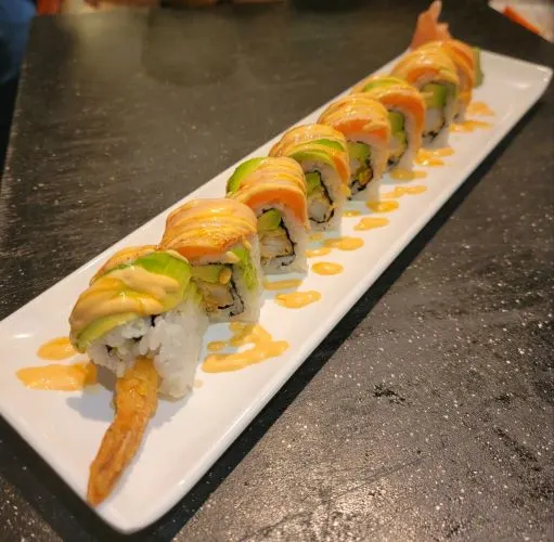 Honey Roll — Shrimp tempura, avocado, cucumber and sweet chili sauce, topped with seared salmon and avocado drizzled with spicy mayo and honey.