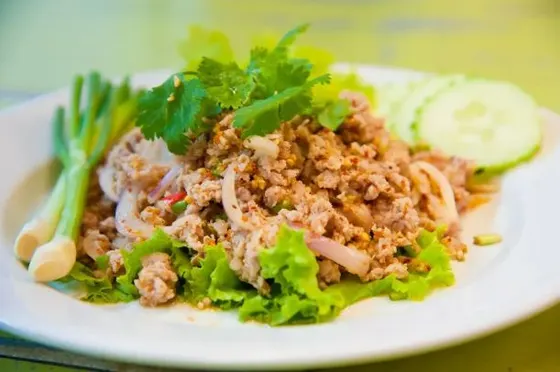 Larb Gai — Ground chicken cooked and tossed in lime juice, fish sauce, ground roasted rice, shallots, green onions, cilantro, and roasted dry chilis.