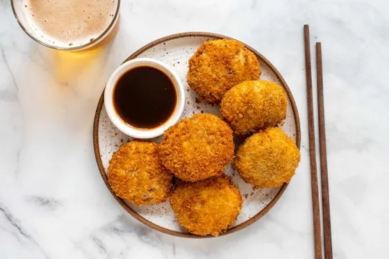 Yasai Korokke (Japanese Potato Croquettes) — Mashed potatoes mixed with carrots, corn, and peas rolled in wheat flour and breadcrumbs, then deep fried and served with okonomiyaki sauce.