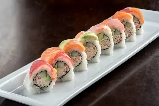 Rainbow Roll — Three kind of raw fish and avocado on top of California roll.