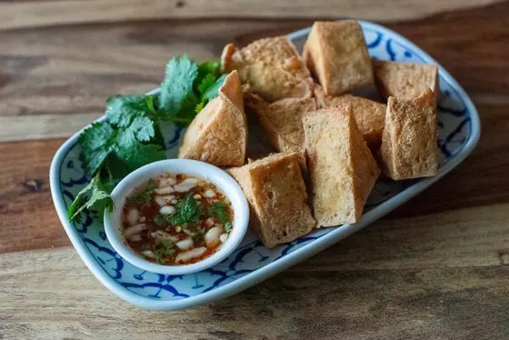 Tofu Tod (Fried Tofu) — Firm tofu deep fried to a golden crisp and served with ground roasted peanuts in a sweet and tangy chili sauce.