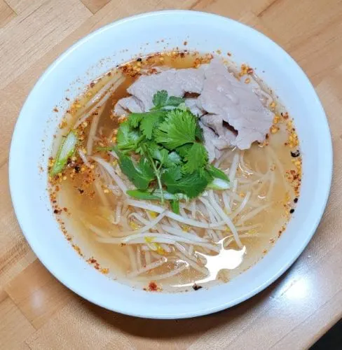 Kuay Tiew Tom Yum Bo Ran — Fresh rice noodles or egg noodles, pork or chicken, bean sprouts, green onions, and cilantro in spicy broth with ground roasted peanuts.
